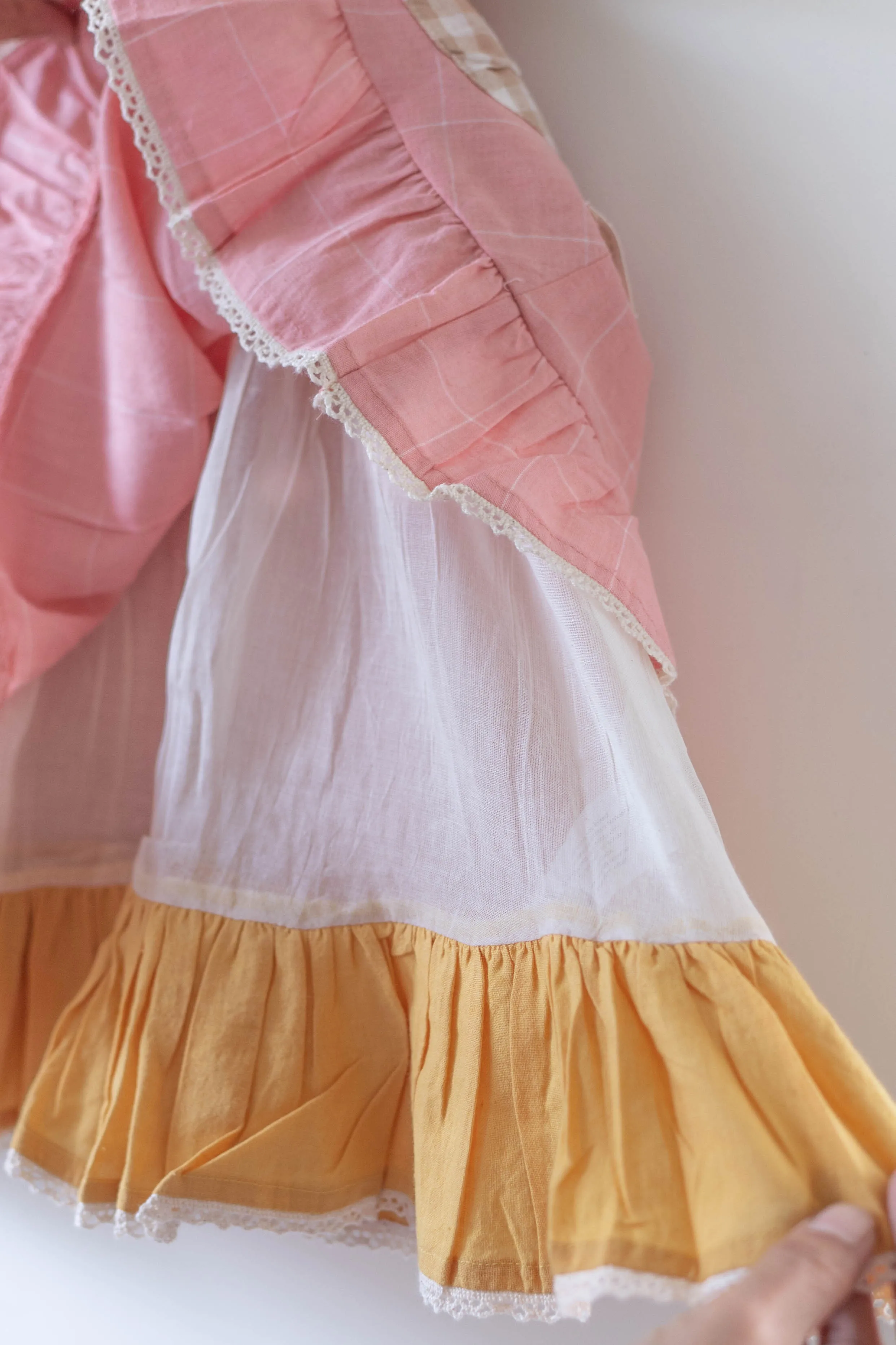 Pocketful of sunsets' sleeveless dress in peach pink with yellow frill in handwoven cotton